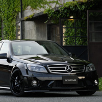  C63 AMGの迫力ある黒のボディ。500馬力にせまる心臓をもつモンスターマシンは猛獣と呼ぶにふさわしい。建物の映り込みが精悍なプレスラインを強調するようにクルマを置く。その在感に負けないブラックのGC-05Kの存在感もまた秀逸だ。全身をブラックでコーディネイトしたC63 AMGは、もはや兵器と化した。／Camera:EOS-1Ds Mk2 #Shutter Speed:1/25 #F Number:8.0 #ISO:100 #Lens:24-70mm #Focal Length:unknown #By:Chikara Kitabatake #Location:Chiba